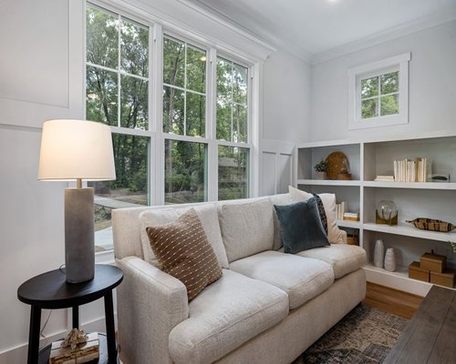 A cozy indoor reading space with natural light streaming through a large clean glass window
